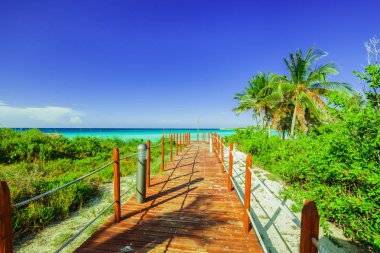 plaj ve sakin turkuaz Okyanusu tropikal Bahçe Cayo Coco Island, Küba ile önde gelen ahşap köprü görünümü