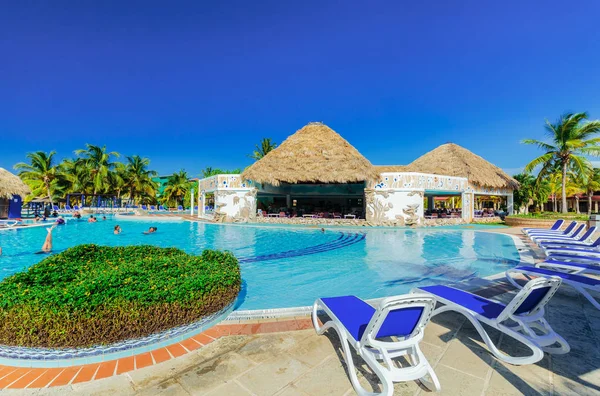Vista de los jardines del hotel con agradable piscina acogedora y personas que se relajan en el agua en el jardín tropical —  Fotos de Stock
