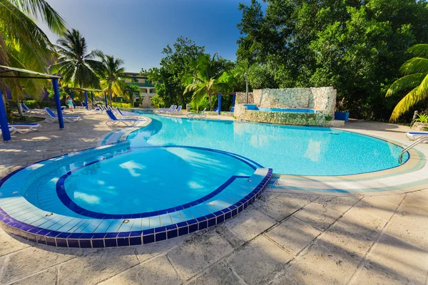 Increíble vista de los jardines del hotel con agradable piscina acogedora y gente en el fondo en el jardín tropical — Foto de Stock