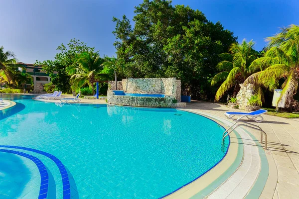 Jardines del hotel con agradables azulejos de cerámica acogedora piscina en el jardín tropical en un día soleado agradable — Foto de Stock