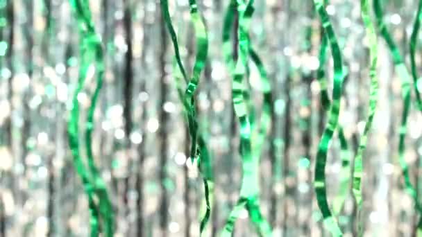 シルバーボケを背景にグリーンのティンセル 輝く光と輝く粒子の美しい動的背景 お祭り気分 クリスマスや休日のテーマ — ストック動画