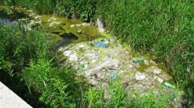 Çevresel kirlilik ekolojik sorun kavramı. Plastik torbalar, şişeler, çöpler ve çöpler nehirde yüzüyor. Çöp gibi nehre atılan plastik şişeler. Su kaynaklarının ekolojik felaketi