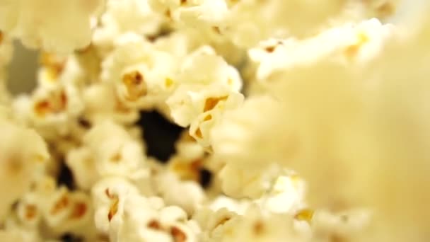 A pattogatott kukorica koszorúja focilabda formájában lóg a tányér fölött. A popcorn háttere a sporthírekhez. Kreatív háttér. Egy meghívó focimeccsre. A kamera belülről néz. — Stock videók
