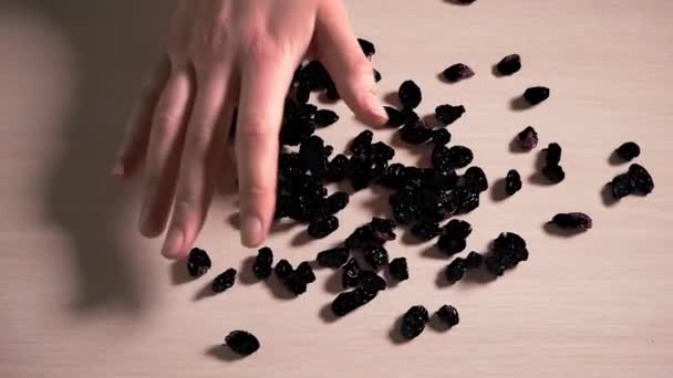 The girl takes the raisins from the table — Wideo stockowe