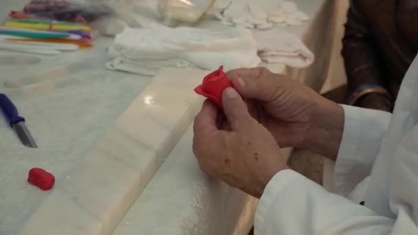 A man makes a rose out of marzipan — Stockvideo