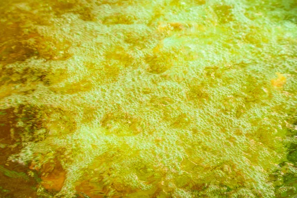 Hot boiling frying oil surface on pan background.