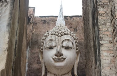 Tayland 'ın Sukhothai eyaletindeki eski tarihi parktaki Srichum tapınağındaki antik Phra Ajana Buda heykeli..