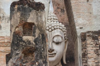 Tayland 'ın Sukhothai eyaletindeki eski tarihi parktaki Srichum tapınağındaki antik Phra Ajana Buda heykeli..