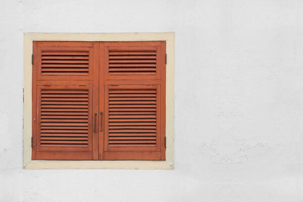 Natural old wood window on dirty white cement wall background.