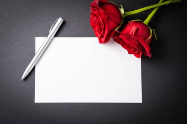 Kırmızı güller ve üzerine siyah bir arkaplan yazmak için hediye kartı. Sevgililer Günü kavramı, yıldönümü veya Anneler Günü.