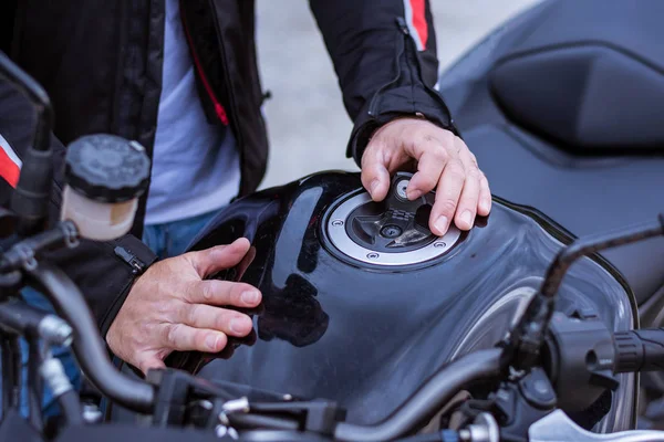 Motociclista rimuovere il tappo del gas dalla sua moto . — Foto Stock