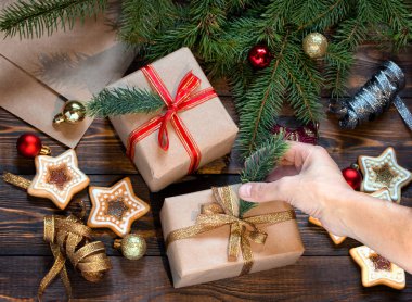 Kadınlar Noel hediyelerini ladin dalları, ev yapımı kurabiyeler ve Noel ağacı oyuncaklarıyla ahşap bir masaya koyar.. 