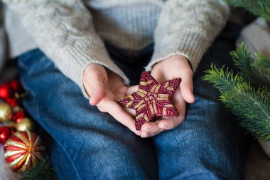 Kadınların elinde Noel ağacı için kırmızı yıldız. Üst Manzara. Noel, yeni yıl, doğum günü konsepti 