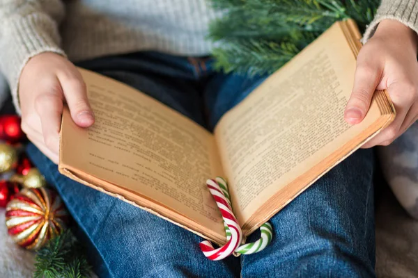 Kitap ayracı olarak iki çizgili lolipop okuyan genç bir kadın..