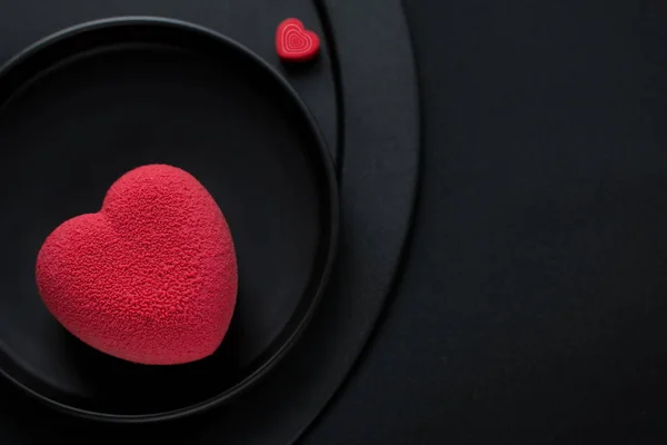 Concepto de San Valentín. Pastel de terciopelo rojo en forma de corazón sobre un fondo negro . — Foto de Stock