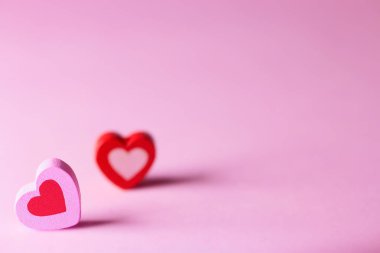 Sevgililer Günü konsepti. Pembe bir yüzeyde iki tahta kalp. Aşkın, mutluluğun ve bağlılığın sembolü.. 