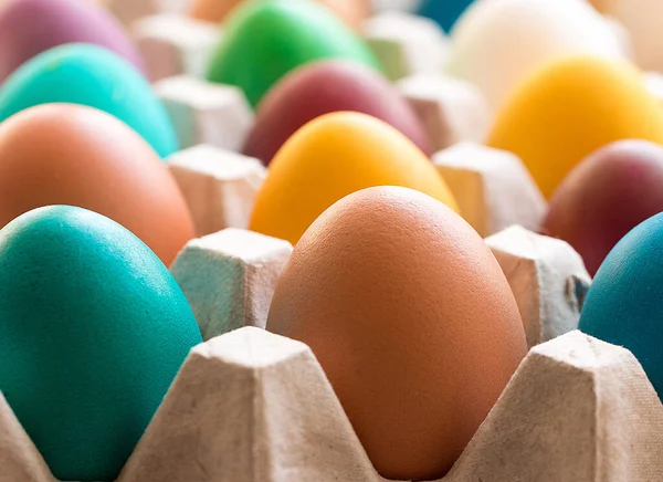 Diferentes ovos de Páscoa coloridos na bandeja de ovos de papelão. Decoração de Páscoa. Foco seletivo . — Fotografia de Stock