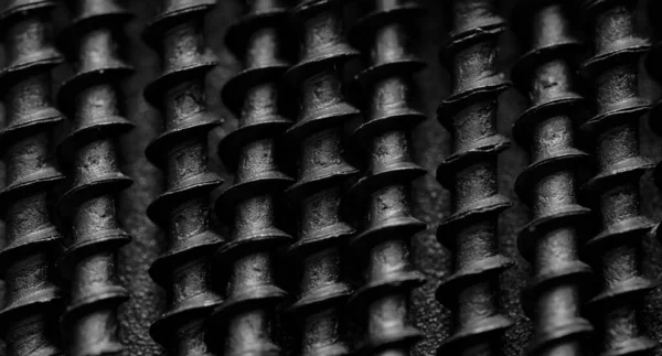 Parafusos de metal preto em uma superfície de metal preto. Macro. Fechar . — Fotografia de Stock