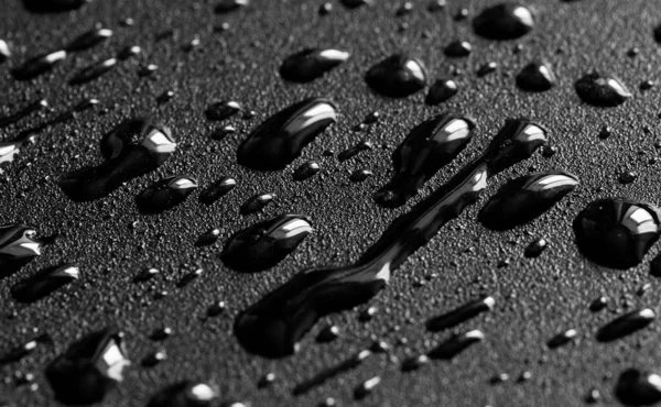 Gocce d'acqua sulla superficie di metallo nero . — Foto Stock