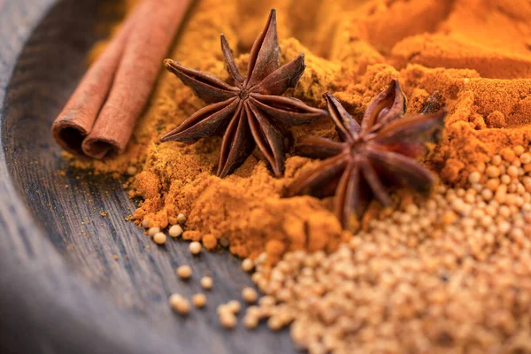 Olika kryddor. Kanelstänger, stjärnanis, senapsfrön och gurkmeja på en träplatta. Makro — Stockfoto