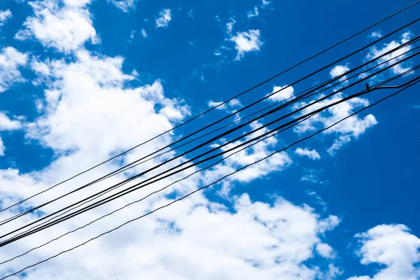 電力消費の概念とアイデアのための青い空と電気線ケーブルの背景 — ストック写真