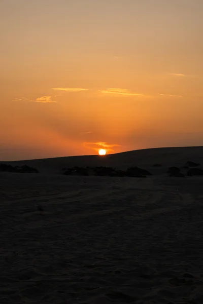 Vista de la hermosa puesta de sol en Desert Safari Camel Ride, un hito para las actividades del desierto, en Al Wakrah, Qatar. Imagen De Stock