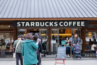 Tokyo, Japonya - 17 Mart 2019: Tokyo, Japonya 'da pembe kiraz çiçekleri veya Sakura bahar sezonu sırasında Starbucks Kahve Ueno Onshi Park kuyruğunda bekleyen müşterileri görmek.