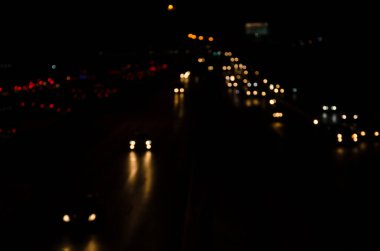 Gece yoldaki araba ışıklarının bulanık görüntüleri..