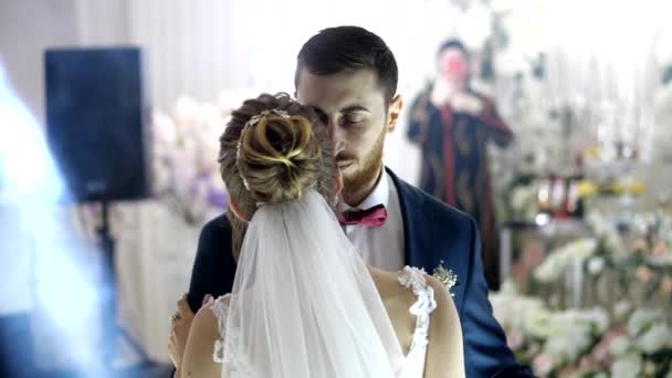 Пара в свадебном наряде танцует против гостей, фотографирующих — стоковое видео