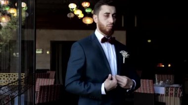 Damat, restorana karşı çekilen düğün fotoğrafları için poz veriyor.