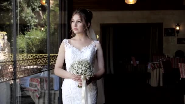 Жених приближается невеста и объятия держась за руку возле стеклянной двери — стоковое видео