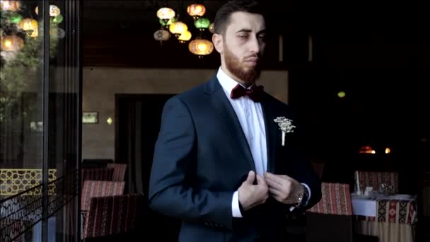 Damat, restorana karşı çekilen düğün fotoğrafları için poz veriyor. — Stok video