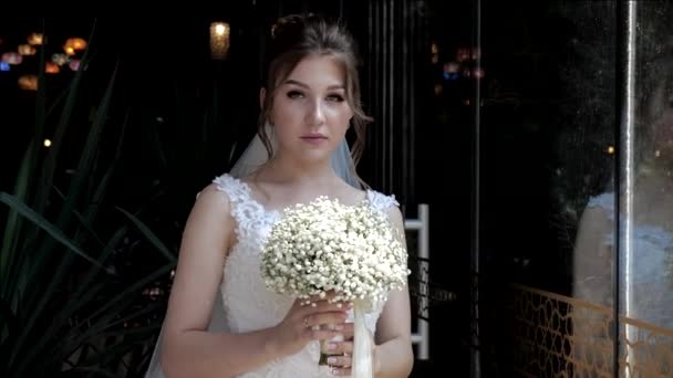 Невеста позирует возле стеклянной стены в ресторане на свадьбе — стоковое видео