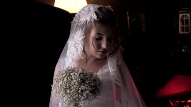 Evli bir kadın, düğünde çiçek buketinin arkasına saklanır.