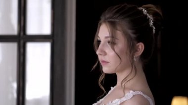 Bukleli ve mücevherli kız düğün fotoğrafı için poz veriyor.