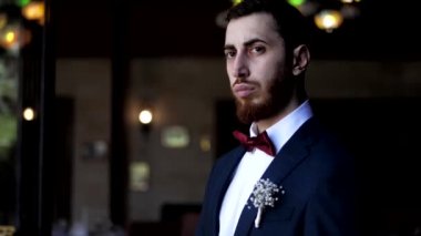 Klasik gelinlik giymiş damat kravatını düzeltir ve yana bakar.