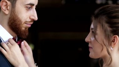 Gelin, damat papyonunu yavaş çekimden önce ayarlar.
