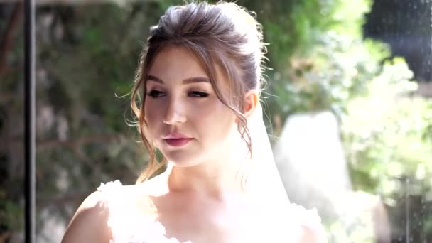 Novia positiva en vestido blanco contra el parque verde cámara lenta — Vídeo de stock