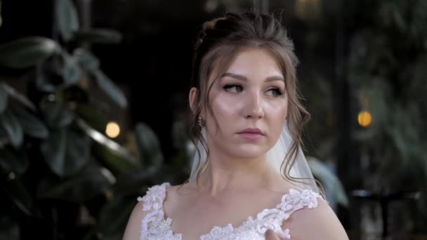 Hübsche Braut steht neben tropischen Pflanzen in Halle-Zeitlupe — Stockvideo