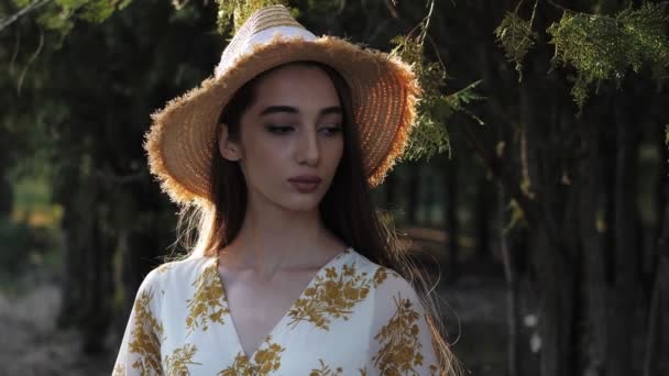 Model poseert naar beneden kijkend tegen bomen in groen park closeup — Stockvideo