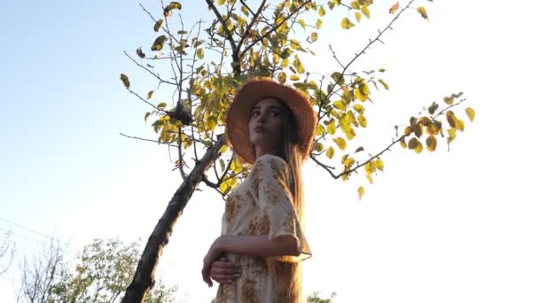 Chica bonita con el pelo muy largo se levanta contra el árbol verde — Vídeos de Stock