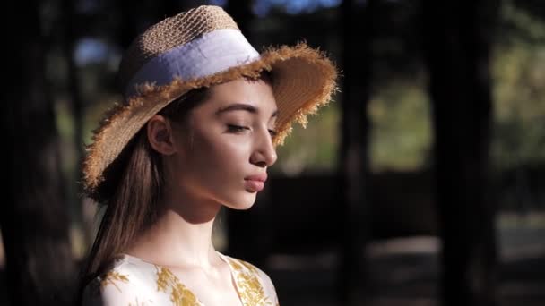 Mujer con estilo en sombrero de paja camina contra el parque de cámara lenta — Vídeos de Stock