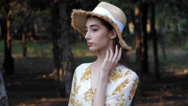 Ragazza tocca cappello di paglia posa contro verde natura paesaggio — Video Stock