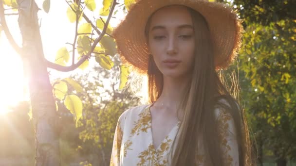 Modelo con el pelo suelto muy largo posa de pie en el árbol verde — Vídeos de Stock