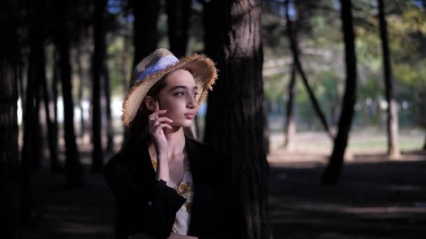 Dame en paille jaune chapeau tient la main sur le cou dans la forêt sombre — Video