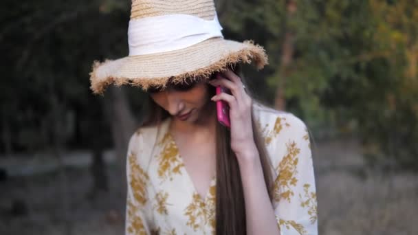 Morena em chapéu de palha e vestido fala em smartphone moderno — Vídeo de Stock