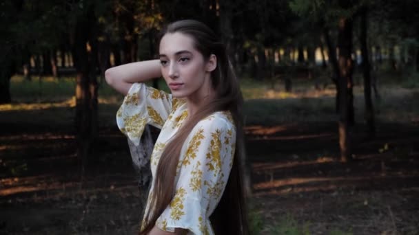 Nő elegáns ruha rögzíti a hosszú haj a parkban lassított felvétel — Stock videók