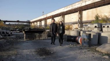 Çift eski beton kanalizasyon halkalarıyla çorak arazide yürüyor.