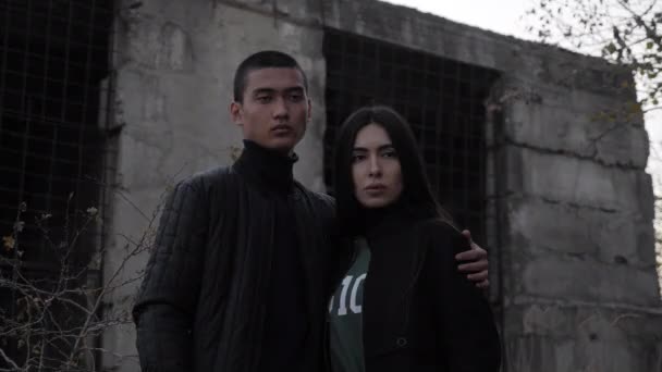 Chica y chico pose por abandonado edificio al atardecer cámara lenta — Vídeos de Stock