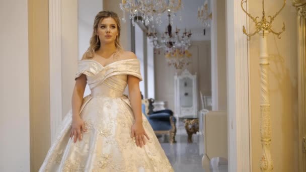 Ξανθιά νύφη με βασιλικό φόρεμα ποζάρει κοιτάζοντας κάτω στο δωμάτιο — Αρχείο Βίντεο